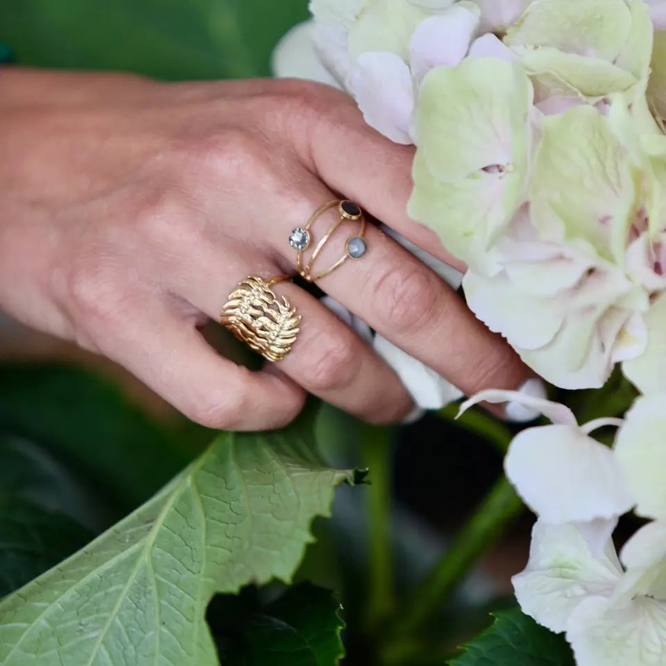 Bague feuillage AXELLE en acier inoxydable doré portée au doigt 