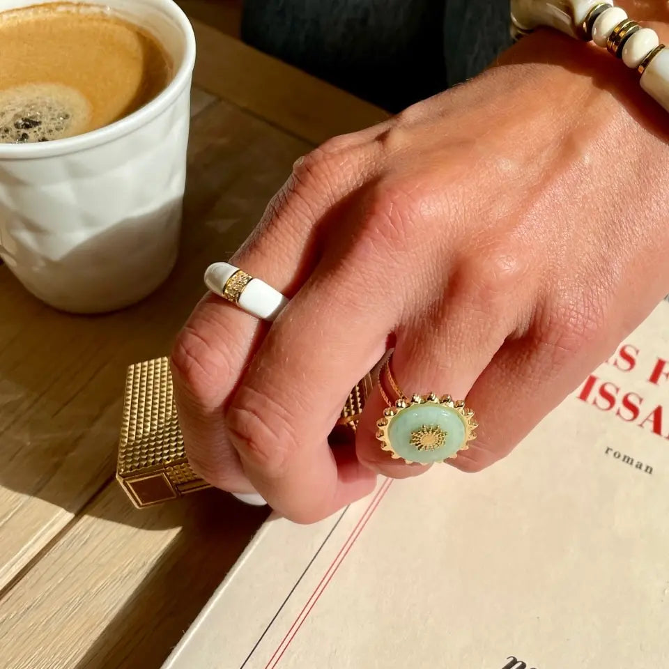 Bague fine en acier inoxydable ornée de strass au centre et d’une finition colorée blanche portée au doigt 2