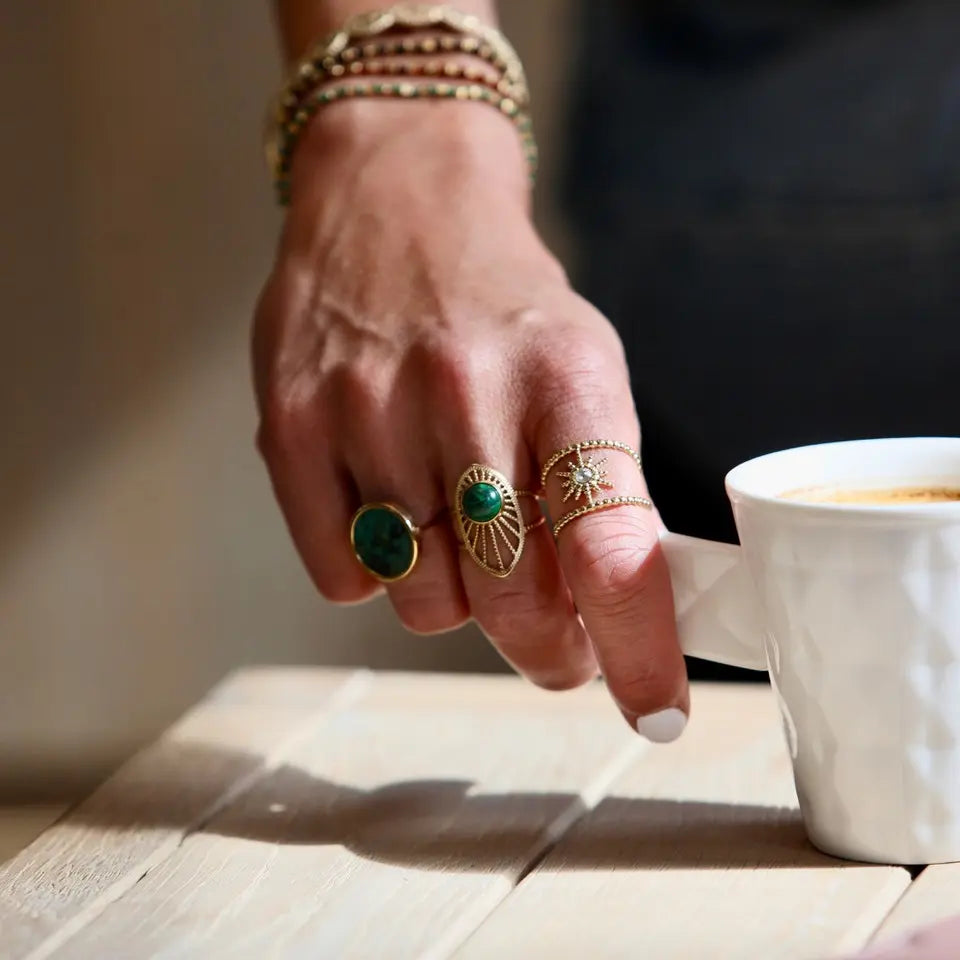 Bague en acier inoxydable ovale ajourée sertie d’une malachite portée au doigt