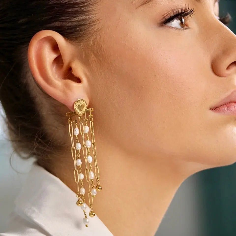 Boucles d’oreilles pendantes composées d’une barre étoilée avec des franges à maillons en acier inoxydable et des franges en perles d’eau douce portées aux oreilles