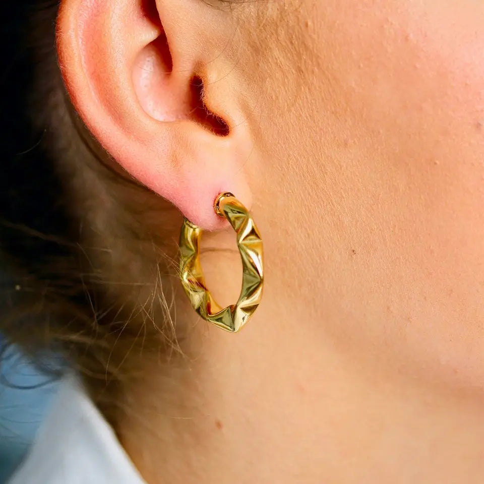 Boucles d’oreilles anneaux structurées en acier inoxydable doré portées aux oreilles