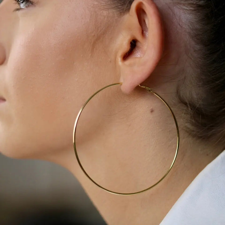 Boucles d’oreilles créoles fines en acier inoxydable doré (75mm) portées aux oreilles