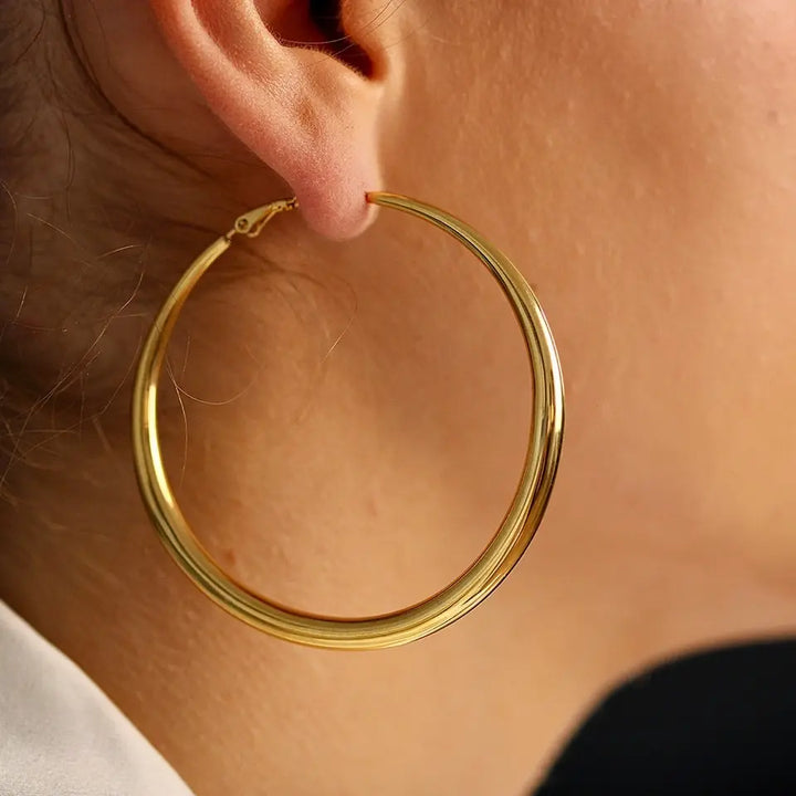 Boucles d’oreilles créoles épaisses en acier inoxydable doré (65mm) portées aux oreilles