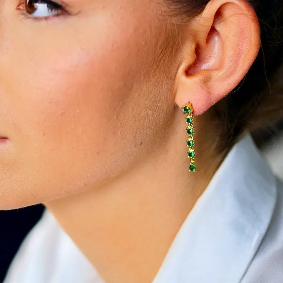 Boucles d’oreilles longues strass en acier inoxydable composées de six strass vert portées aux oreilles