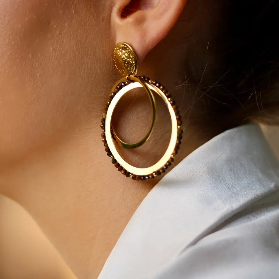 Boucles d’oreilles pendantes composées de deux anneaux croisés en acier inoxydable et pierres naturelles onyx portées aux oreilles