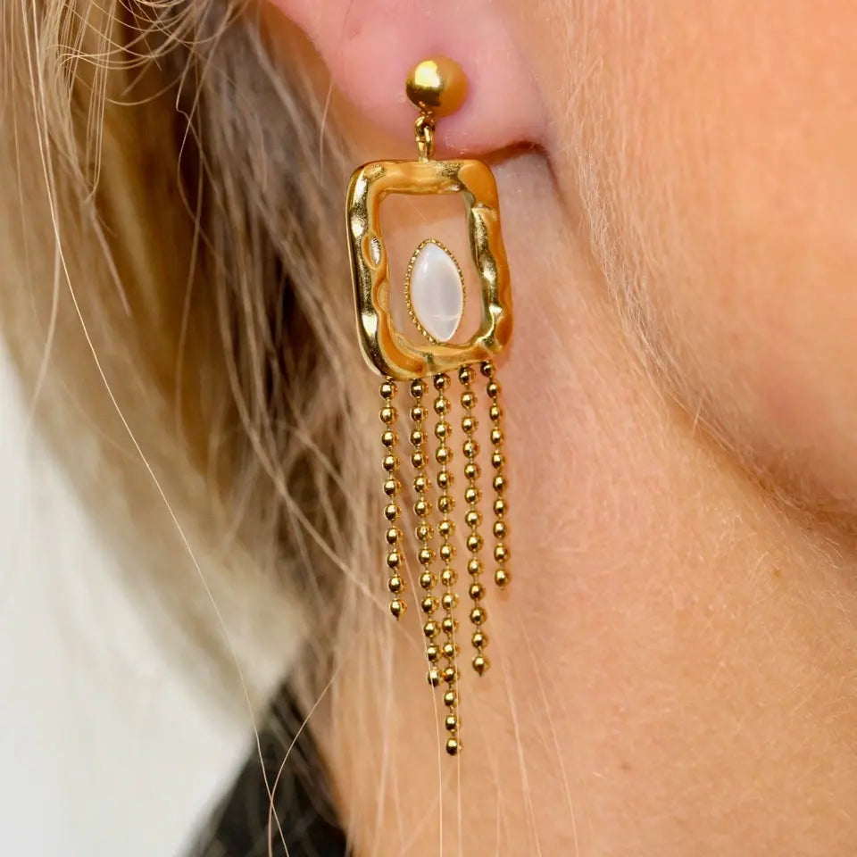 Boucles d’oreilles pendantes à franges en forme de trapèze ornées d’une nacre portées aux oreilles
