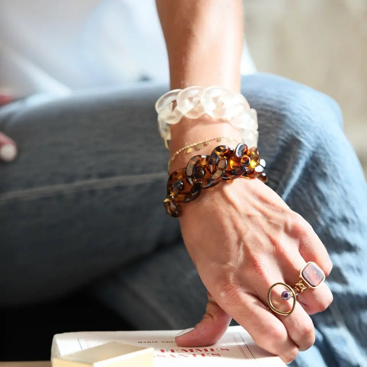 Bracelet grosse maille en plastique porté au poignet en accumulation