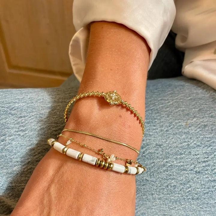 Bracelet jonc croix ajustable en acier inoxydable doré ornée de strass porté au poignet