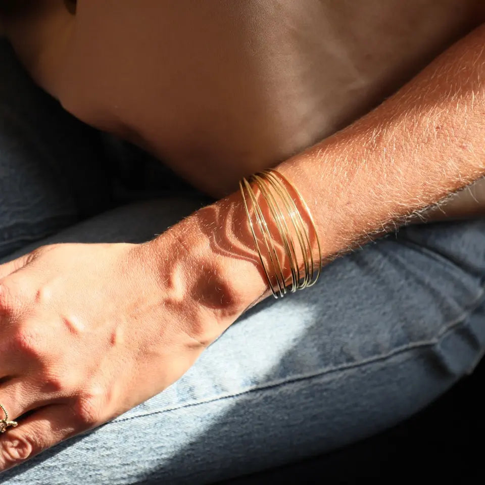 Bracelet jonc multiple en acier inoxydable doré avec un effet lisse porté au poignet (2)