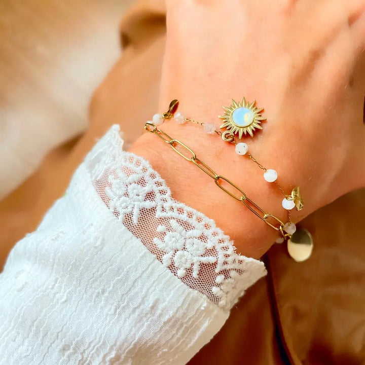 Bracelet 2 rangs composé d'une chaîne à maillon et d’une chaine en maille fine avec des pierres d’agate blanche ainsi qu’un soleil orné d’un cristal white opal porté au poignet