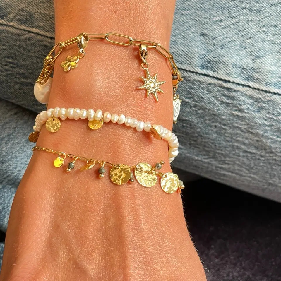 Bracelet perles d’eau douce avec pampilles en acier inoxydable en forme de médaillon martelé porté au poignet
