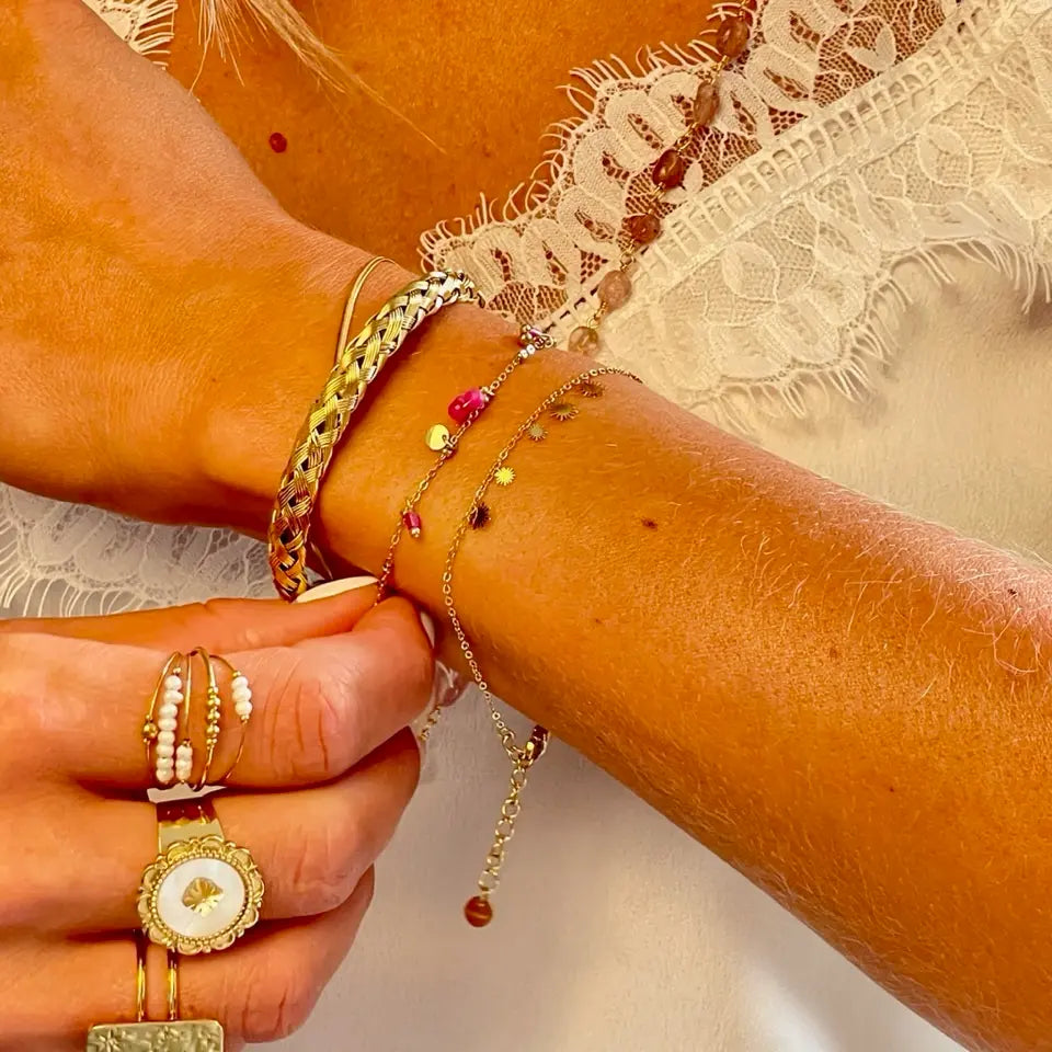 Bracelet soleil maille fine composé de pampilles au motif solaire en acier inoxydable porté au poignet en accumulation