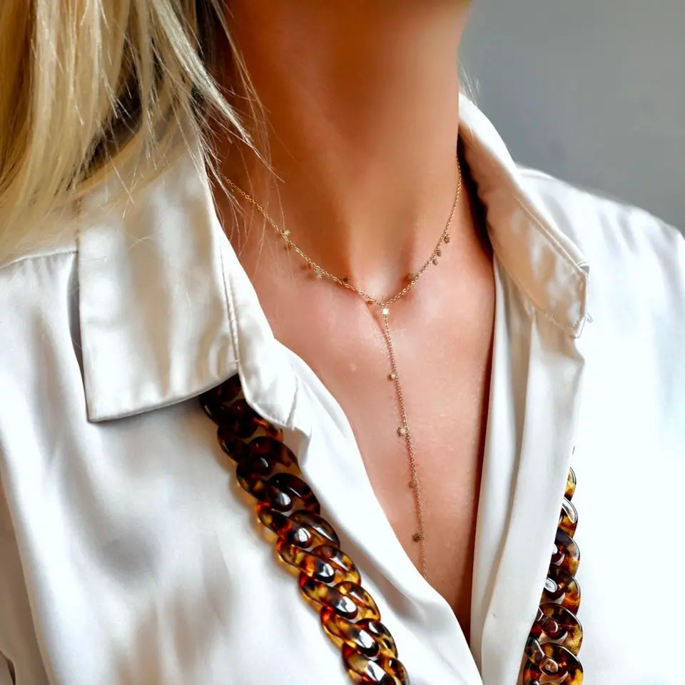 Collier en Y composé d'une chaîne fine avec mini-soleils en acier inoxydable doré porté autour du cou