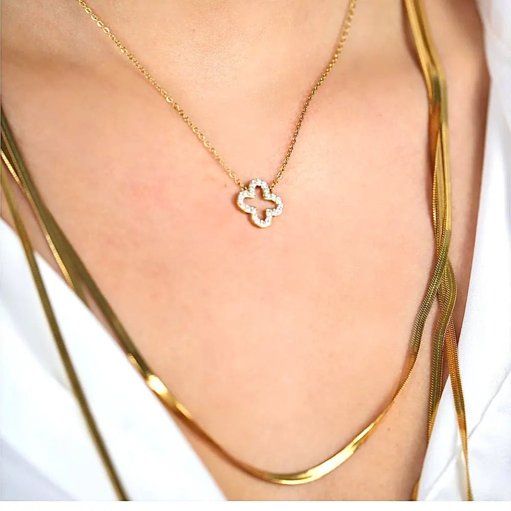 Collier ras de cou ROMY en acier inoxydable doré composé d’un médaillon en forme de trèfle ajouré orné de strass blanc porté au cou