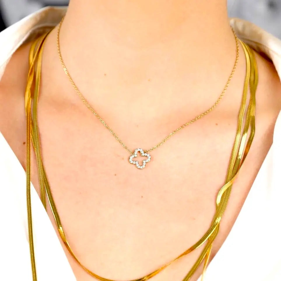 Collier ras de cou ROMY en acier inoxydable doré composé d’un médaillon en forme de trèfle ajouré orné de strass blanc